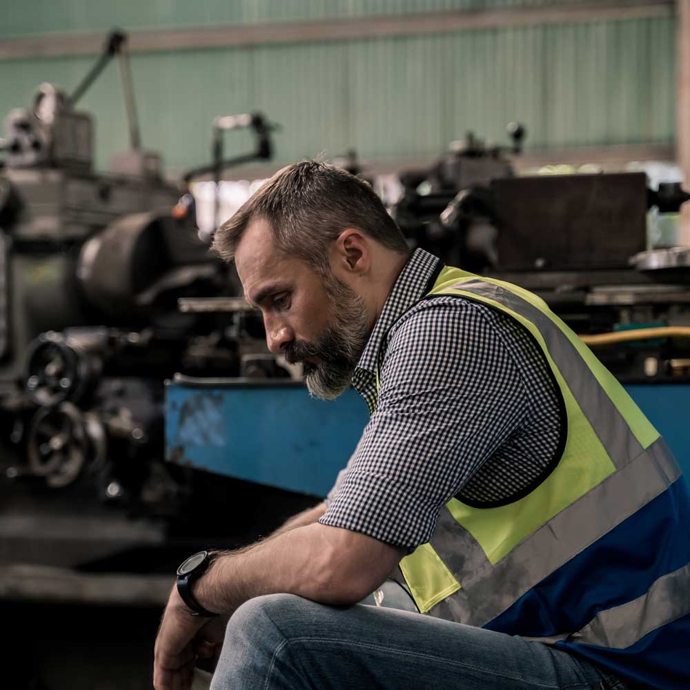 male worker looks sad on factory floor