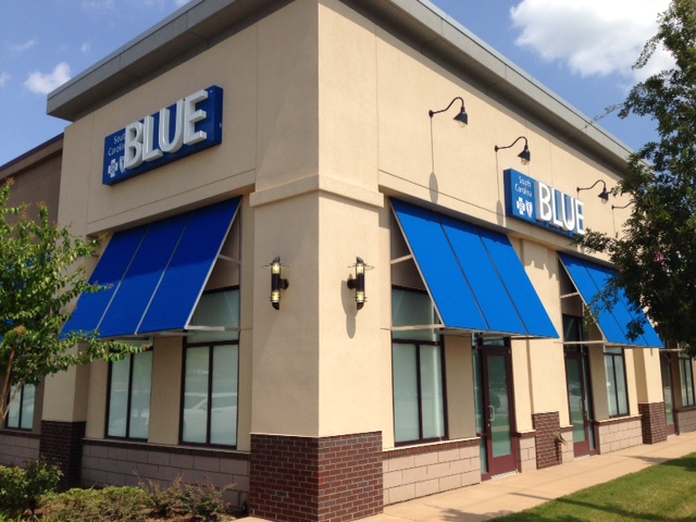 building with blue awnings and blue retail sign