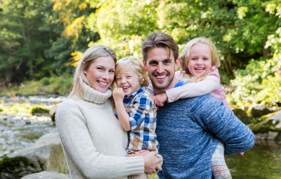family in the woods standing near the river